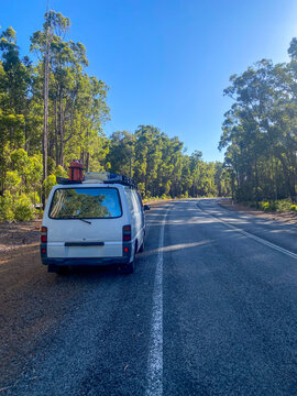 White camper van on road trip through forest