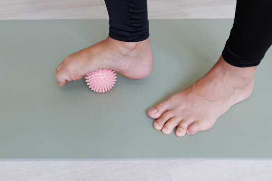 Massage ball exercise under the forefoot trains arch control, toe mobility, plantar stimulation and foot muscle strength for preventive gymnastics and flat feet support.