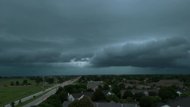 Dark storm clouds forming over the countryside. Dramatic shelf cloud approaching across open fields with an ominous sky, Wide drone shoot