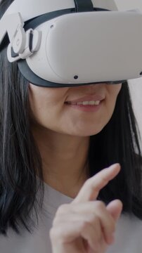 Slow motion of woman using virtual reality glasses moving hands enjoying modern device indoors at home. Entertainment and innovative gadget concept.