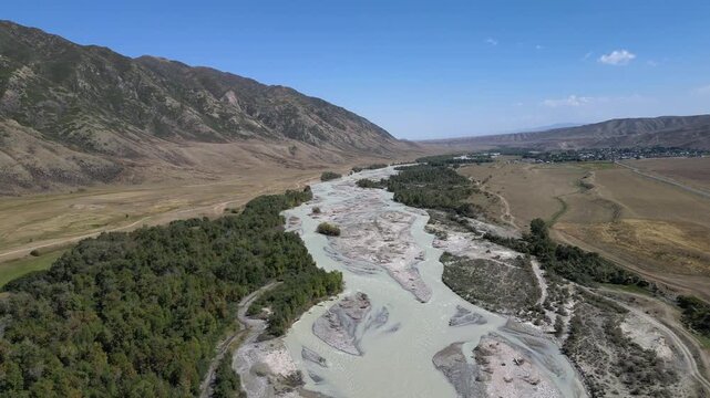 Amazing aerial view flying over the chilik river valley in the beautiful tien shan mountains of kazakhstan during a sunny summer day