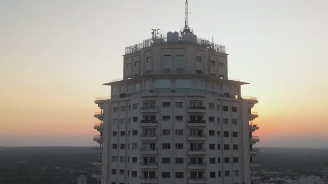 A cinematic aerial shot of the iconic Edificio Espana building in Madrid, Spain, captured during a vibrant sunset. Ideal for travel documentaries and urban real estate marketing.