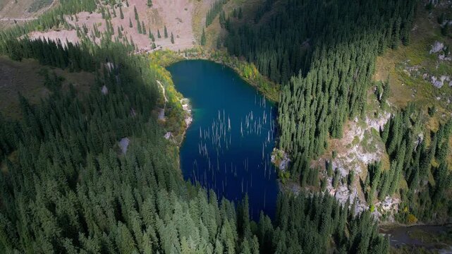 Majestic aerial view of the famous kaindy lake in kazakhstan. Beautiful turquoise water revealing a unique submerged forest