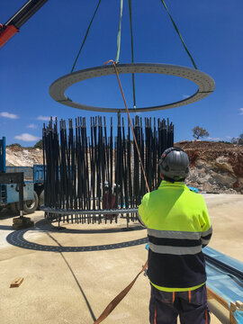 Worker guiding wind turbine foundation rebar cage installation