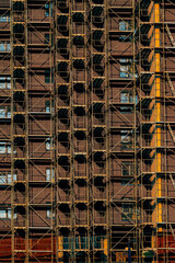 Modern multi-story building under construction covered in scaffolding. © Bits and Splits