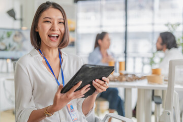 Obraz premium Portrait of confident mature Asian businessman with clasped hands looking at camera in modern corporate office, demonstrating senior leadership, trustworthy expertise, professional wisdom, and authori