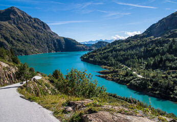 Fototapeta premium Bright turquoise alpine lake and winding mountain road