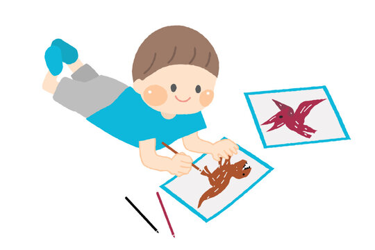 床に寝そべってお絵描きをする男の子