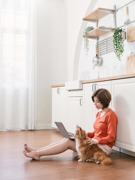 Asian short hair woman work with computer on the floor with her pet dog animal. Coffee break time.  Sme small business work from home online technology. Weekend stay work from home.