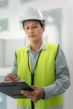 inspector or engineer is inspecting construction and quality assurance new house using a checklist. Engineers or architects or contactor work to build the house before handing it over to the homeowner