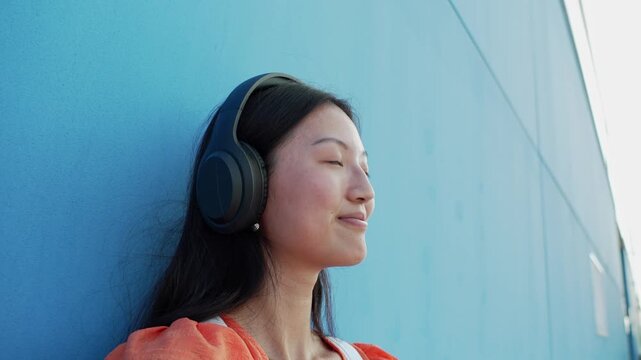 Young asian woman enjoying music with headphones