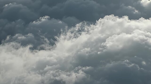 Dramatic storm clouds moving through dark sky, cinematic aerial view of thick grey cumulus clouds, moody atmospheric weather background for film production and environmental documentaries