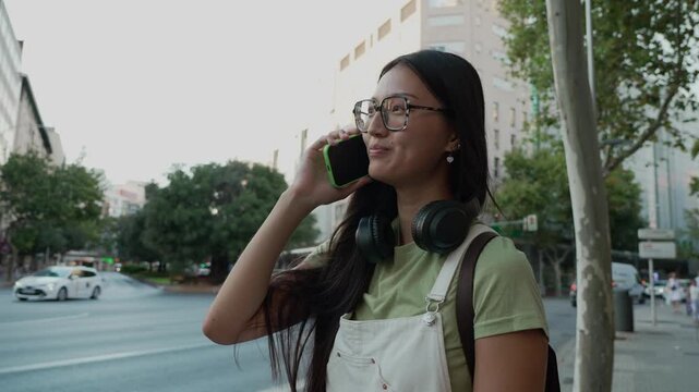 Young asian woman talking on smartphone in the city