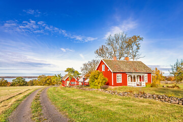 Rural landscape view in autumn with a idyllic red old cottage © Lars Johansson