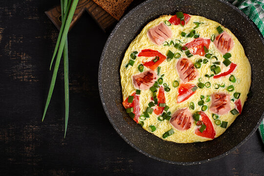 Rustic Breakfast Omelet with Sausage and Vegetables on Dark Background. Top view