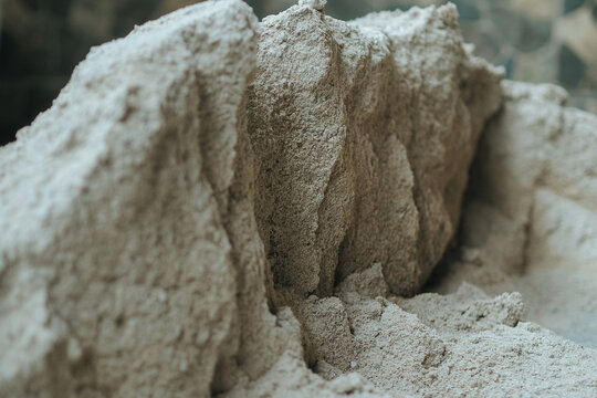 close-up view of a coarse sand heap showing rough textures and natural beige earth tones.