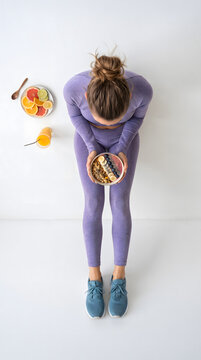 Top View Fit Woman in Purple Sportswear Lying on Floor Holding Acai Smoothie Bowl with Fruits and Orange Juice &mdash; Healthy Lifestyle Fitness Nutrition Mockup Template