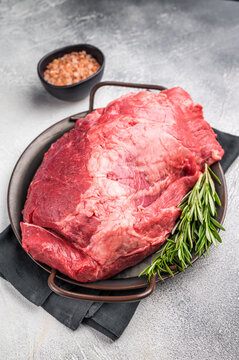 Beautifully arranged raw boneless beef shank pieces on a rustic platter, inviting creativity in the kitchen for delicious slow-cooked meals. grey background. top view