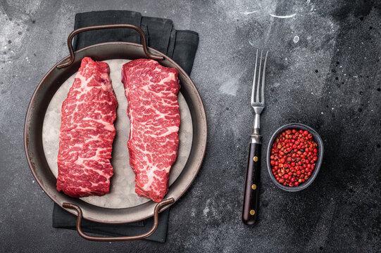 Premium denver, chuck eye steak, beautifully presented, ready for seasoning. A versatile cut ideal for barbecue enthusiasts and steak lovers alike. black background. top view
