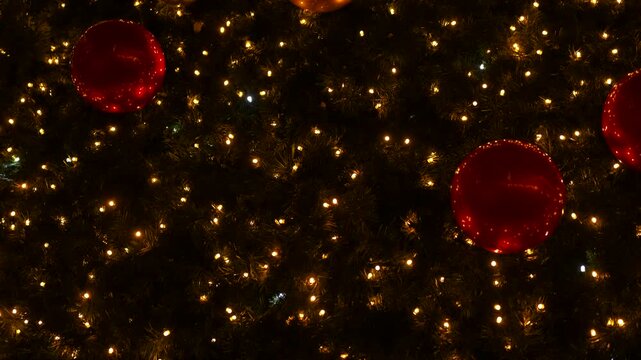 Flashing christmas lights with red and gold ornaments. Christmas tree decorated with beautiful red and gold baubles and warm sparkling string lights creating a festive and magical atmosphere
