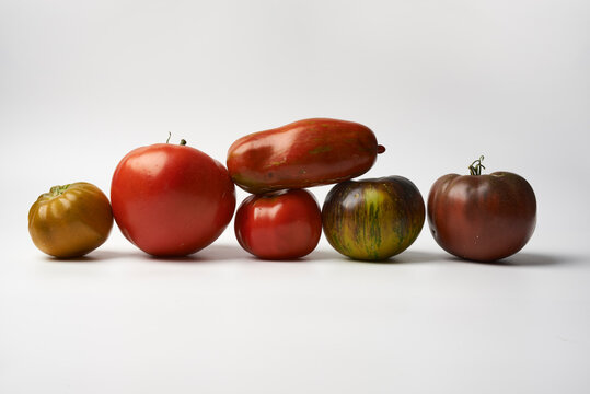 Assorted heirloom tomatoes of different colors and varieties on white background