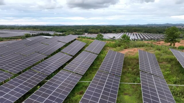 aerial view of solar panel arrays on green hillside