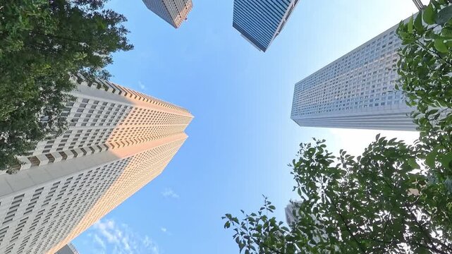 TOKYO, JAPAN - JUL 2026: Looking up at skyscrapers and high-rise office buildings in Nishi-Shinjuku business district at sunset. Japanese corporate business, financial hub and urban technology concept