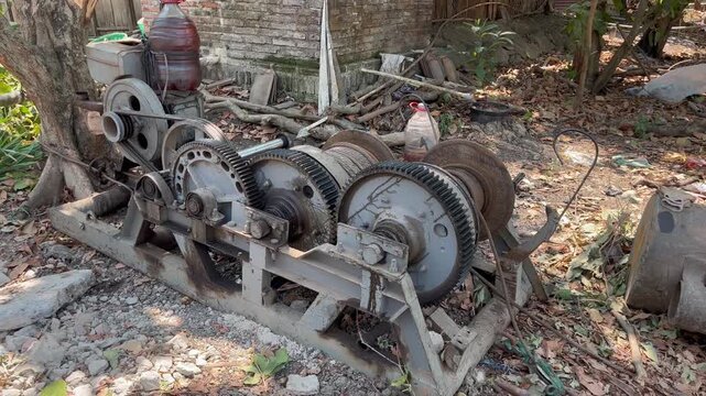 Vintage diesel engine winch machine with heavy gears and pulleys