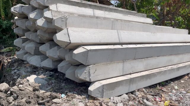 Stack of precast concrete piles on a construction site outdoors