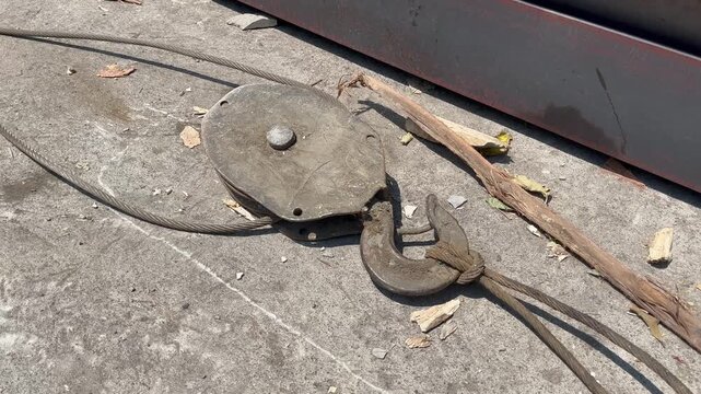 Close up of vintage rusty steel wire rope pulley block with lifting hook