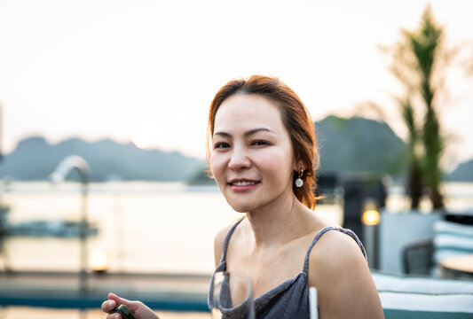 Happy Asian woman enjoying a beautiful vacation at sunset