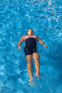 Young girl floating peacefully on her back in pool