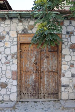 The courtyard gate of a traditional house in Konya. A two-part wooden gate set amidst stone walls.