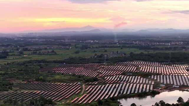 solar photovoltaic panels arranged in neat rows under sunset sky