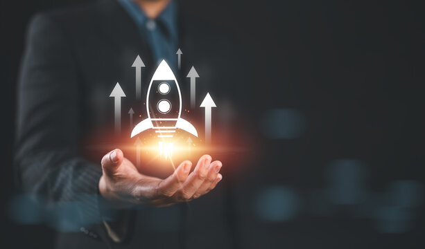 Business growth concept. Professional businessman projecting a holographic rocket symbolizing startup success and growth acceleration. Rising earnings, increasing financial profits, Wealth fast,