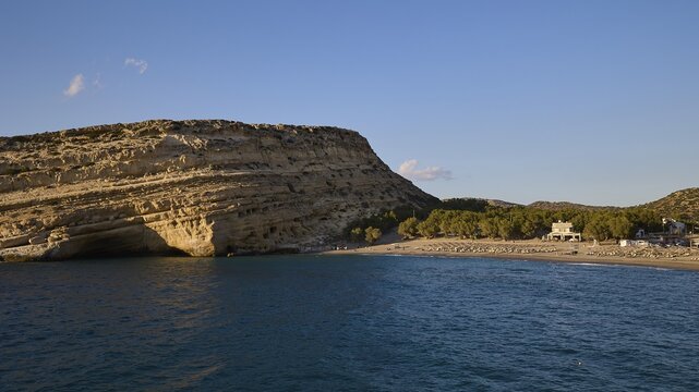 Neolithic caves, former hippie paradise, rocky coastline with calm sea and clear blue sky in the afternoon, Matala, south coast, Crete, Greek Islands, Greece