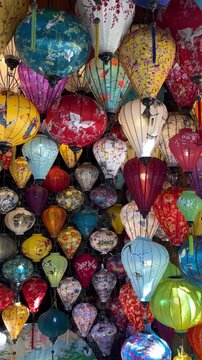 A vibrant display of colorful lanterns in various shapes and sizes. The lanterns feature intricate designs and patterns, creating a festive atmosphere.