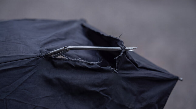 Broken umbrella fabric tearing, metal rib structure exposed by strong wind and adverse weather conditions