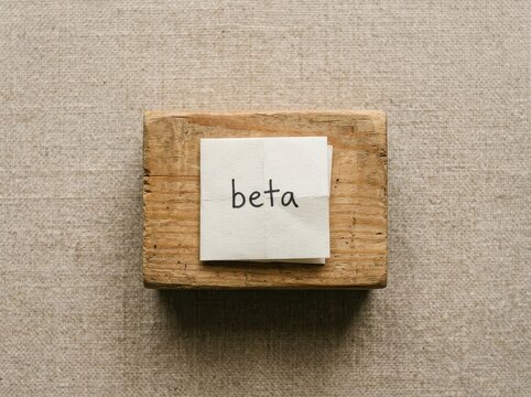 Wooden block with word beta on white paper
