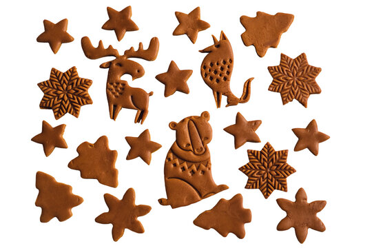 Assorted Christmas gingerbread cookies shaped as animals trees stars and snowflakes arranged as a decorative flat lay pattern isolated on transparent background