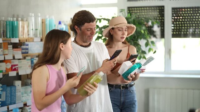 Man with wife and teen daughter in pharmacy scans QR code on drug store assortment items. Client uses link to go to manufacturers website. 