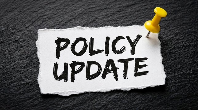 Official announcement of policy update on a paper note against a dark textured background.