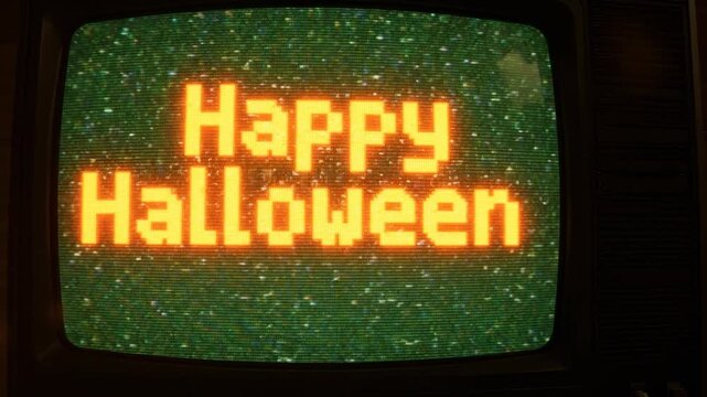 An old television screen displays 'Happy Halloween' in pixelated orange text on a grainy, static-filled green background.