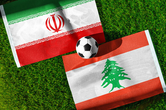 Iran vs. Lebanon football match. National flags on green grass with soccer ball in the middle. Football background for international match.