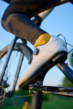 Cyclist wearing cycling shoe clipped into bicycle pedal