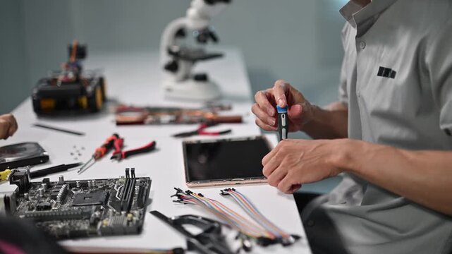 Technician Assembling Electronics Circuitry in Laboratory Workstation