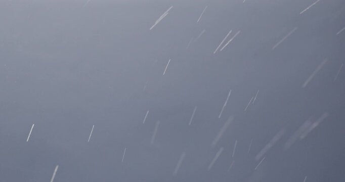 Tiny snow or dust randomly flying in the air, empty space template for objects advertisement. Many dust particles cloud of white powder on empty lit background.