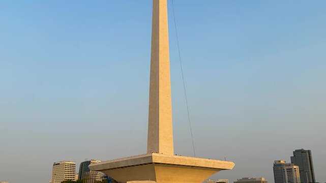 National Monument Monas tower in Jakarta, Indonesia, illuminated by golden sunset light with city skyline behind