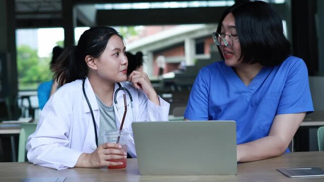 Group medical students and their peers are spending their free time relaxing having drinks and discussing medical academics table in a friendly and relaxed atmosphere at the medical university.
