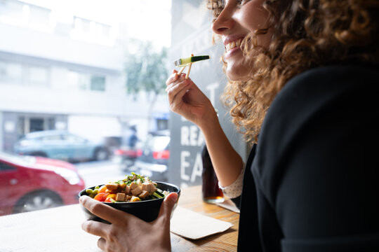 White woman enjoying a healthy bowl meal in an urban cafe